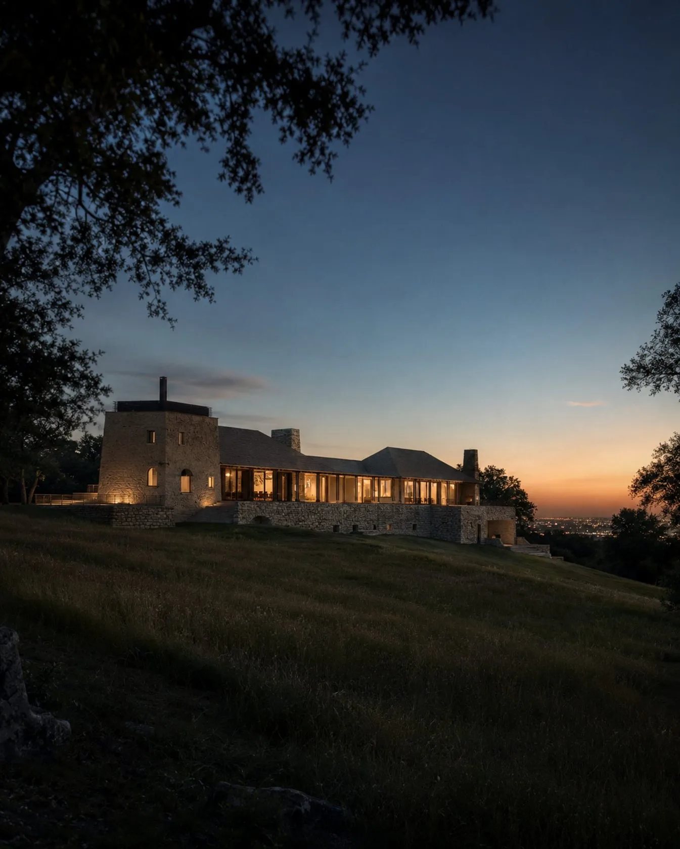 The estate at dusk with warm interior light
